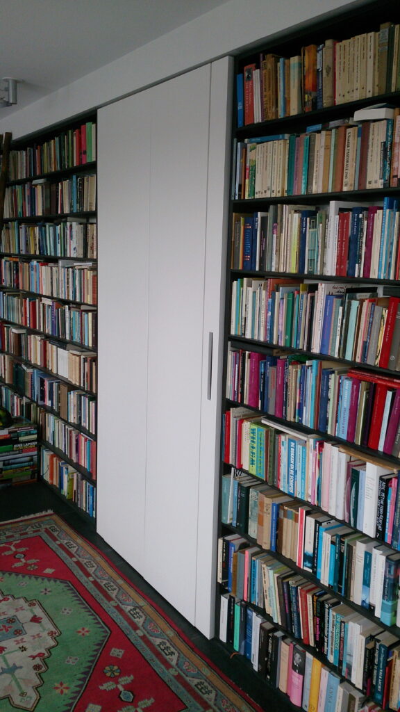 8 meter boekenkast, gerookt Eiken ,massief hout,amsterdam,boekenkast op maat,Boekenwand met kast in het midden die in zijn geheel naar buiten kan scharniere,scharnierende kast op wielenn