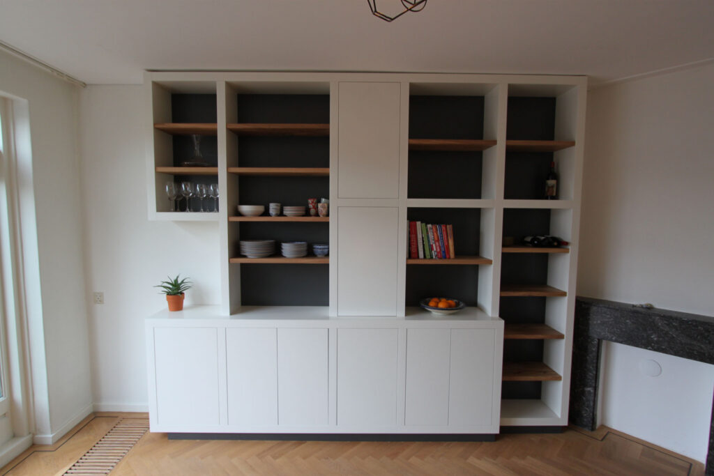 Kast op maat, dikke witte staanders,eikenhouten planken in boekenkast,meubels op maat amstelveen,boekenkast op maat amstelveen,boekenkast op maat amsterdam,wandmeubel op maat amsterdam,dikke witte staanders met eikenhout,meubels op maat amsterdam,wijnrek in kast