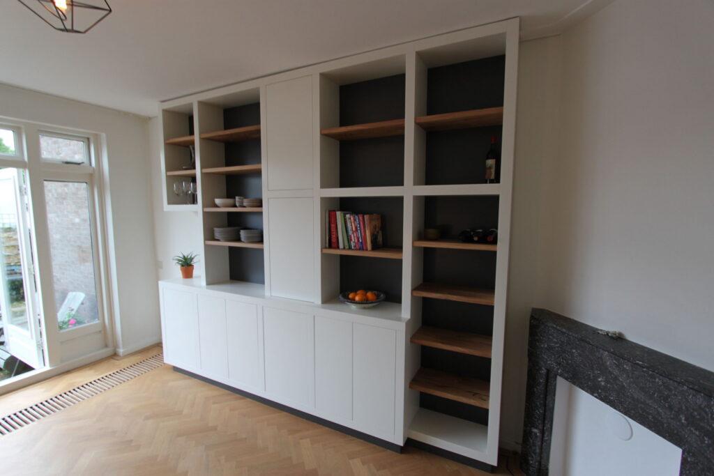 Kast op maat, dikke witte staanders,eikenhouten planken in boekenkast,meubels op maat amstelveen,boekenkast op maat amstelveen,boekenkast op maat amsterdam,wandmeubel op maat amsterdam,dikke witte staanders met eikenhout,meubels op maat amsterdam,wijnrek in kast