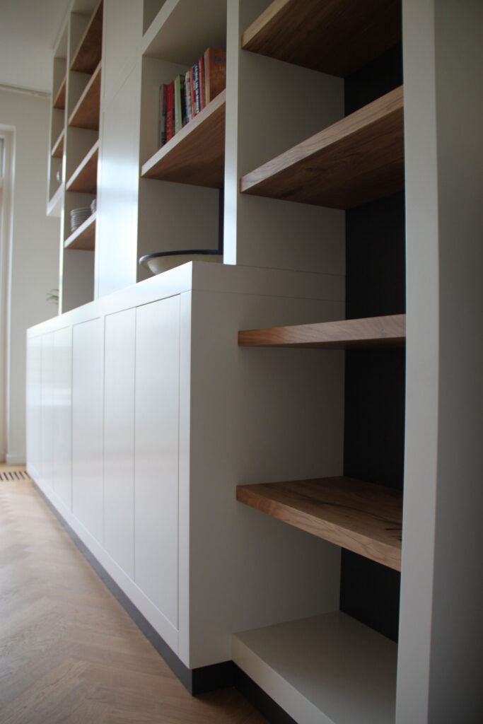Kast op maat, dikke witte staanders,eikenhouten planken in boekenkast,meubels op maat amstelveen,boekenkast op maat amstelveen,boekenkast op maat amsterdam,wandmeubel op maat amsterdam,dikke witte staanders met eikenhout,meubels op maat amsterdam,wijnrek in kast